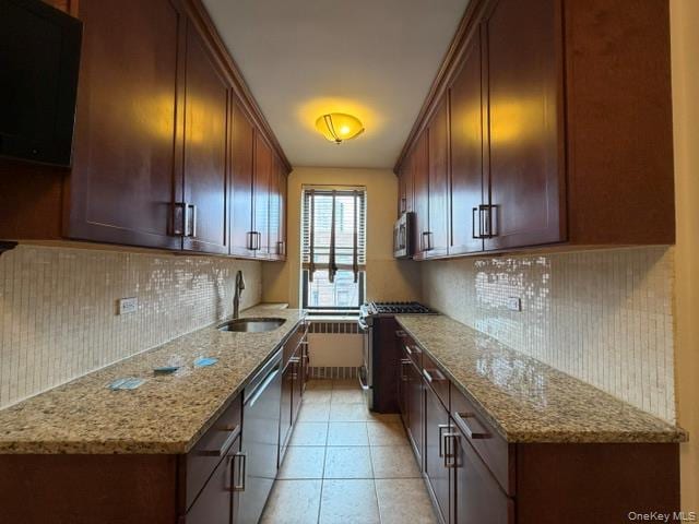 Galley kitchen featuring dark wood cabinetry, light-toned granite countertops, a mosaic tile backsplash, and a stainless steel sink with a gooseneck faucet