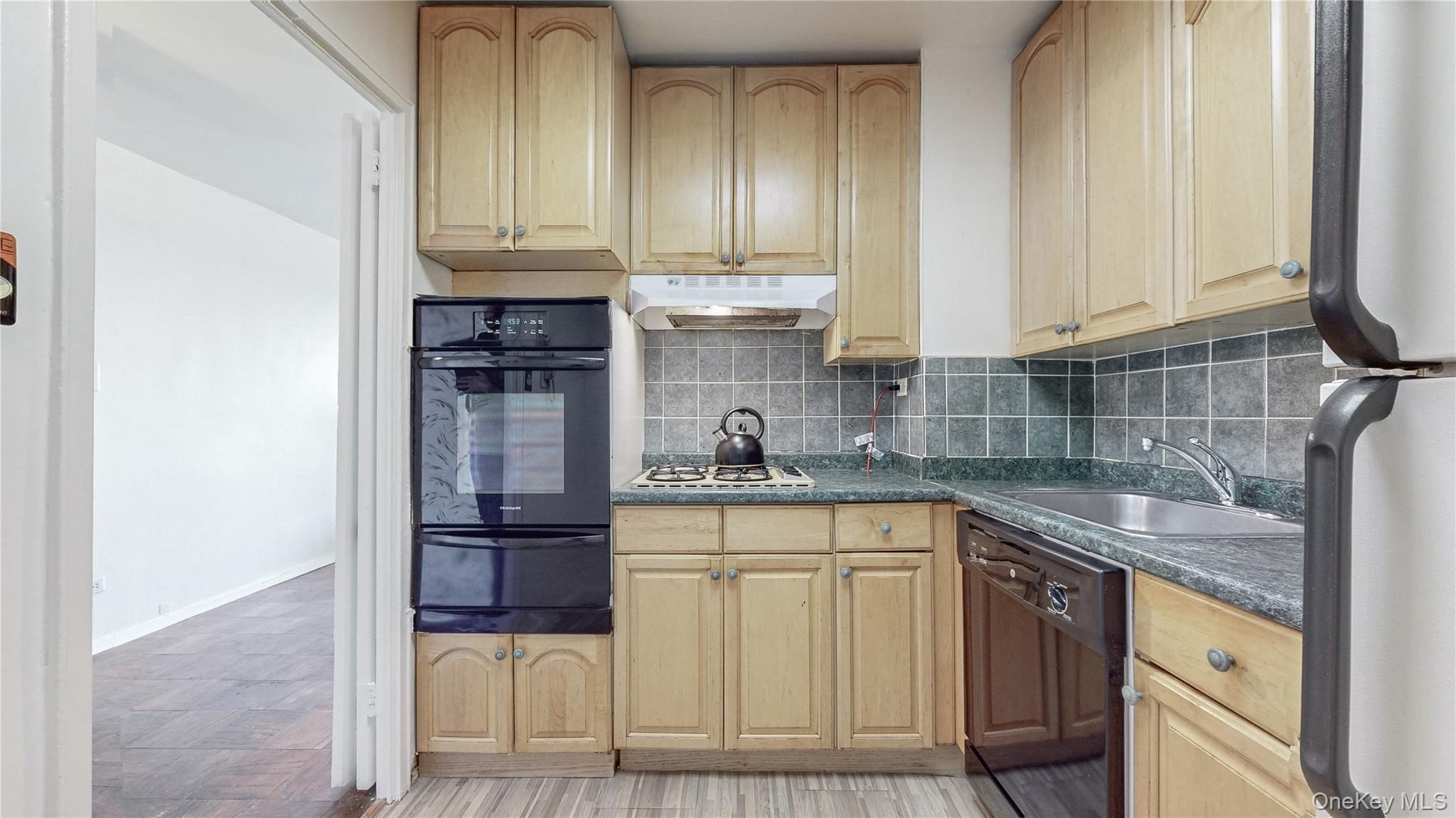 Kitchen featuring wood-finish cabinetry, built-in double oven, gas cooktop, dishwasher, and a stainless steel sink
