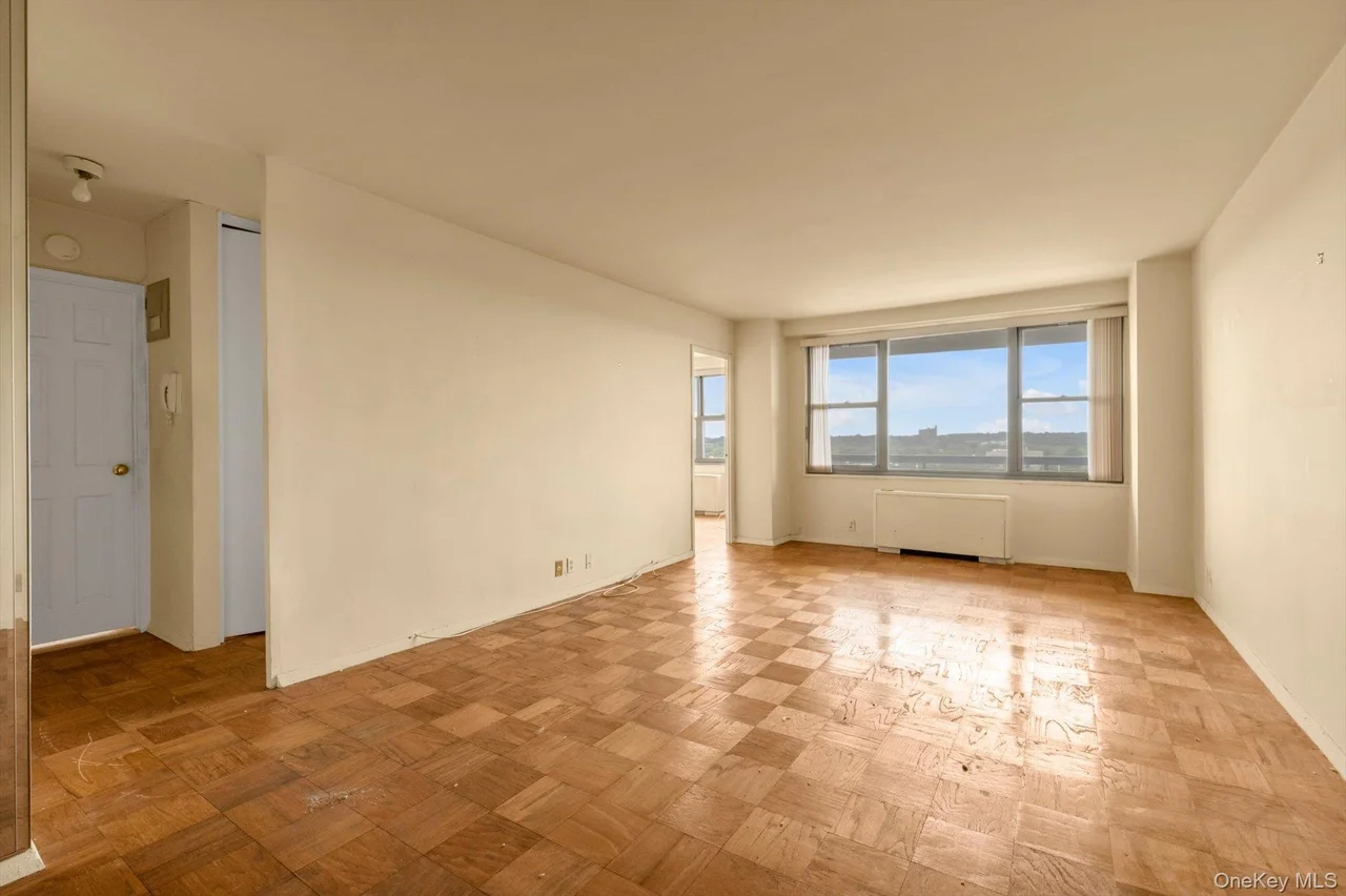 Parquet wood-finish flooring, expansive windows, light-toned walls, and recessed lighting